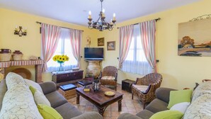 Un salon chaleureux avec une cheminée, des fauteuils confortables et un téléviseur.