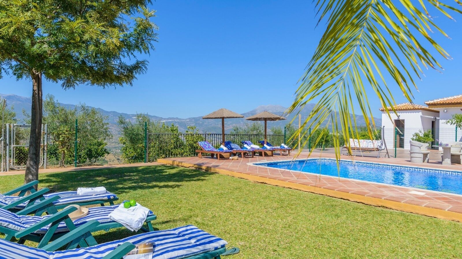 Un espace piscine comprenant des chaises longues, une piscine et une vue sur les montagnes.