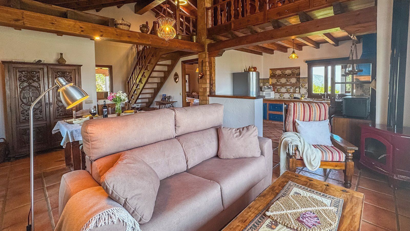 A cozy living room with a sofa, a chair, a lamp, and a fireplace.