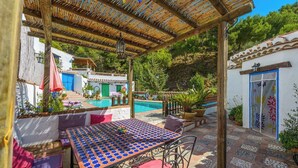 Un área de estar al aire libre cubierta con una piscina al fondo.