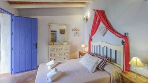 Un dormitorio con cama, cómoda, espejo y una puerta azul.