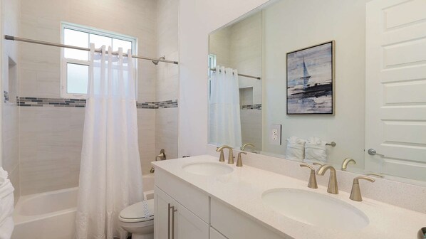 Un baño moderno con dos lavamanos, ducha e inodoro.
