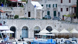Un bâtiment en pierre doté d’une façade traditionnelle en pierre, d’un clocher et d’une enseigne indiquant la présence d’un restaurant et d’un bar.