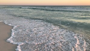 Une plage où les vagues viennent doucement lécher le rivage.