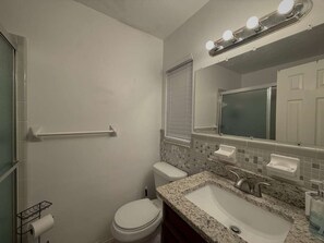 Un baño con inodoro, lavabo y espejo.