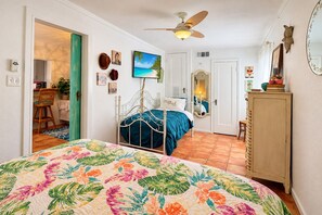 A bedroom with a bed, a ceiling fan, a dresser, and a door leading to another room. - The Bung – A Little Slice of Paradise! 🦩🌺 (Lubbock)