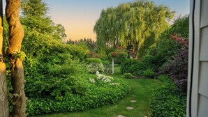 A well-maintained garden with a variety of plants and a central pathway. - Secret Garden Cottage in Old Town Niagara-on-the-Lake (Niagara-on-the-Lake)