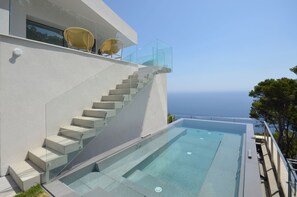 A modern building with a glass staircase leading to a pool area. - Holiday rental villa with swimming pool in Begur, Sa Tuna (Begur)