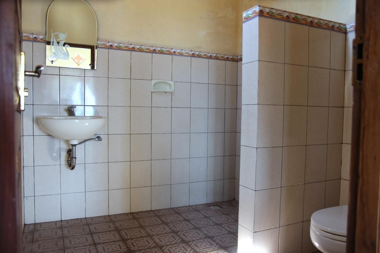 Une salle de bain avec un lavabo blanc, un miroir et des toilettes.
