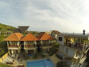 Un resort con varias edificaciones, una piscina y vista al océano.