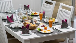 Uma mesa posta com pratos, copos e uma cesta de pão.