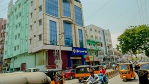 A multi-story building with a blue sign for 'The Grand Inn' on the ground floor. - NAVEED RESIDENCY (Anantapur)