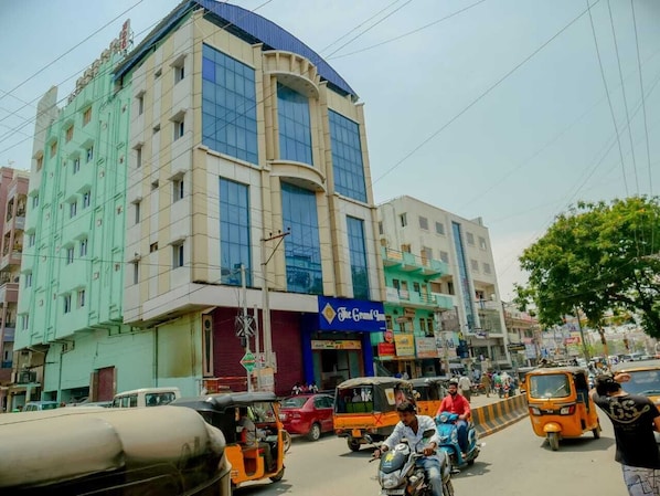 A multi-story building with a blue sign for 'The Grand Inn' on the ground floor.