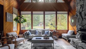 Un loft spacieux avec de hauts plafonds, de grandes fenêtres, une cheminée en pierre et un coin salon confortable.