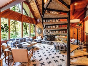 Ein großzügiger Wohnbereich mit Kamin, einer großen Couch und einer einzigartigen Wendeltreppe.