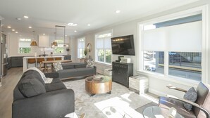 A modern living room with a sofa, coffee table, and TV. - Walk to Hip Bars* Photo wall* porch swings * designer home*  (B) (Nashville)