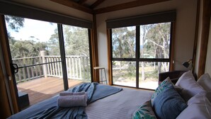 Un dormitorio con una cama grande, vistas a una terraza y un balcón.