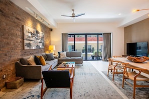 A modern living room with a sofa, coffee table, and dining area.