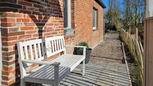 A brick building with a white bench outside.