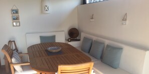 A wooden dining table with a bowl, surrounded by wooden chairs and a cushioned bench.