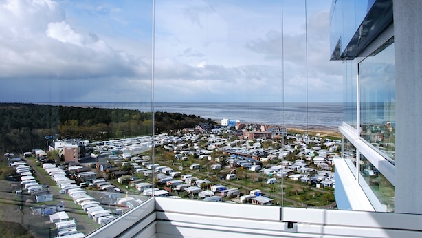 A high-rise building with a view of a residential area and the sea. - Frische Brise (Cuxhaven)
