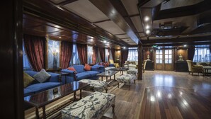 Un amplio salón con sofás, sillones y una mesa de centro.
