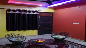 A room with a ceiling fan, black curtains, a door, and two black wire-framed chairs with cushions. - Vacation Village Luxury Tent - A Unit Of Braham Vatika Resort (Pushkar)