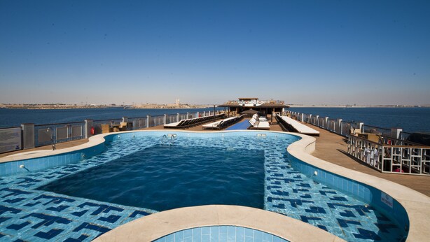 Une piscine offrant une vue dégagée sur la mer, un poste de surveillance pour les sauveteurs et un espace de repos abrité.