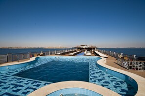 A pool with a clear view of the sea, a lifeguard stand, and a covered seating area. - SUNRISE African Dreams Cruise - Grand Select (Abu Simbel)