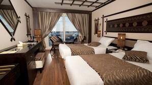 Une chambre d’hôtel avec deux lits, un bureau et une chaise.