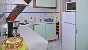 A kitchen with a coffee maker, a basket, and a refrigerator. - Calm rental for 2 persons, the Blue House in Alsace, in a nice medieval village. (Bergheim)
