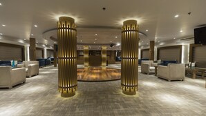 A spacious lobby with a patterned carpet, modern furniture, and illuminated columns. - SUNRISE Semiramis III Cruise (Luxor)