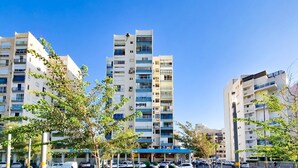 A modern apartment building with multiple floors, balconies, and a clear blue sky. - Charming 3bdr apt with sea view B5 (Bat Yam)