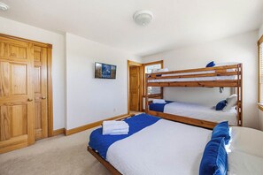 A room with two bunk beds, a wooden door, and a framed picture on the wall. - The After Glow | 940 ft from the beach | Private Pool, Hot Tub (Nags Head)