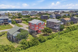 Een woongebied aan de kust met huizen, waarvan sommige balkons hebben, en uitzicht op de zee.