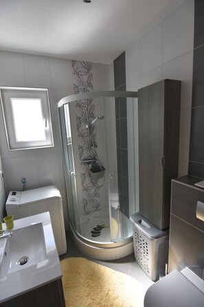 Appartement (Roma) | Badkamer | Een douche, een haardroger, handdoeken, zeep