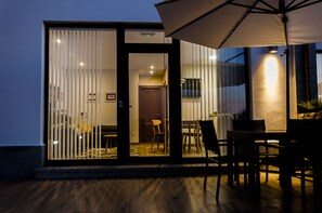 A modern outdoor dining area with a table and chairs, a large umbrella, and a sliding glass door leading to an interior space. -  With pool and views of the jesters. Ideal for families (LLANES)