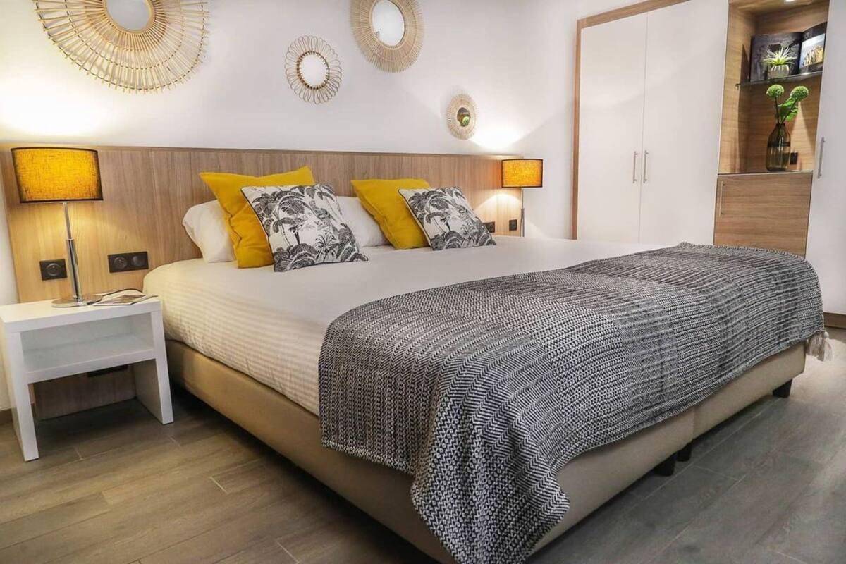 Une chambre à coucher avec un lit, des lampes de chevet, une table de chevet et une armoire.