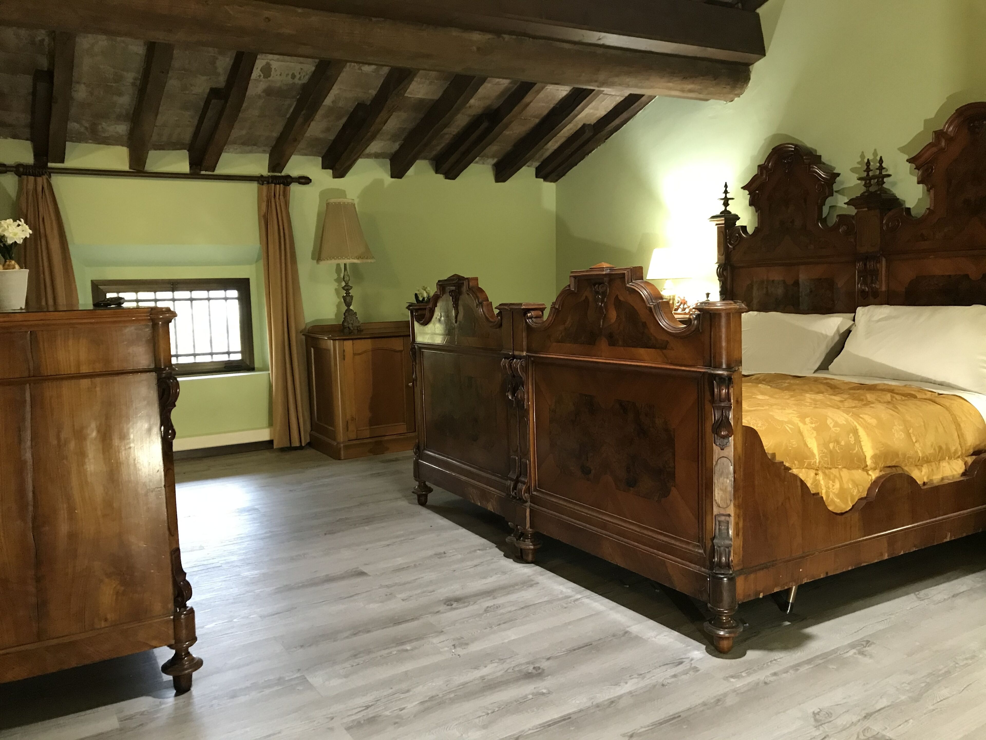 A traditional bedroom with a wooden bed, a nightstand, and a dresser.