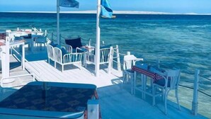 A deck with outdoor seating and a view of the ocean. - Lilly Stay (Hurghada)