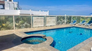 A rooftop pool with clear blue water, a hot tub, and lounge chairs. - Lilly Stay (Hurghada)