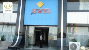 Un hotel chiamato 'JEWEL', con un cartello blu ben visibile e un logo a forma di diamante.