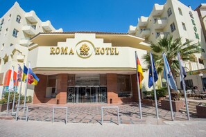 Roma Hotel features a striking entrance with a gold-lettered sign and a symmetrical facade.