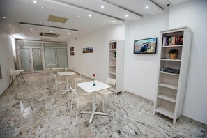Enjoy a serene space with a large window offering a view of the outside, a small table with two chairs, and bookshelves for your belongings.