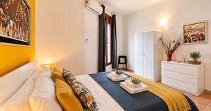 A bedroom with a bed, a wardrobe, a desk, and a painting on the wall. - le casette di Frà (Tolfa)