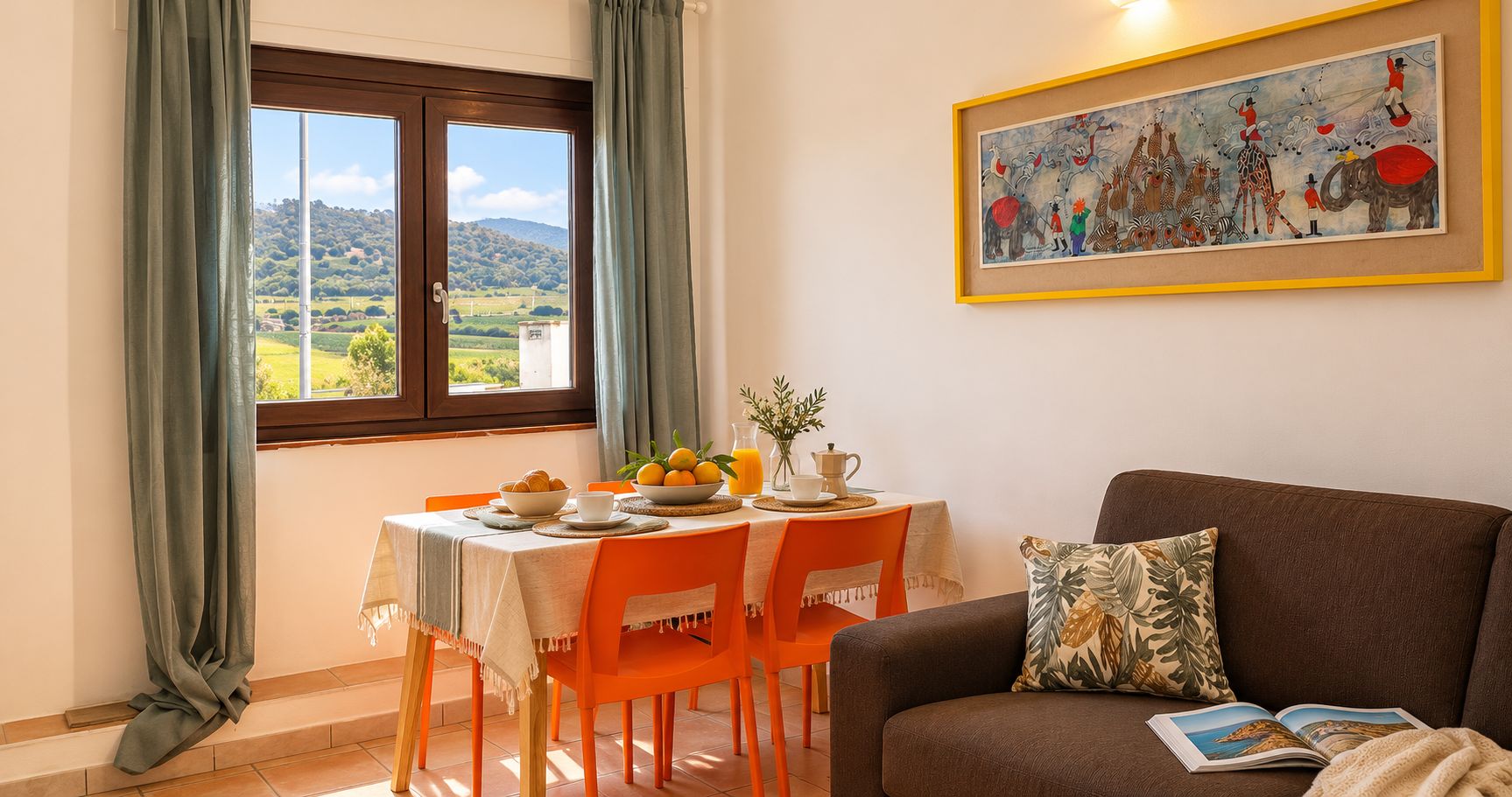 Zona pranzo con tavolo imbandito per due persone, un divano e un quadro appeso al muro.