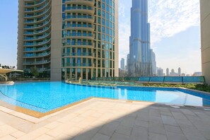 Une piscine avec vue sur un grand immeuble en arrière-plan.