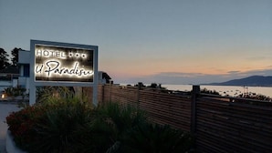 A hotel sign with the name 'HOTEL U Paradise' against a twilight sky. - Hôtel U PARADISU (Grosseto-Prugna)