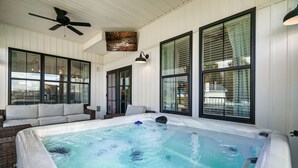 A hot tub area with a ceiling fan, large windows, and a sofa. - Stunning farmhouse with Mountain View’s! (Sevierville)