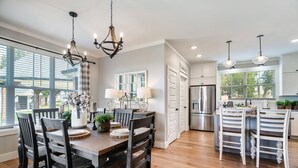 A modern kitchen with a central island, white cabinetry, and a stainless steel refrigerator. - Stunning farmhouse with Mountain View’s! (Sevierville)